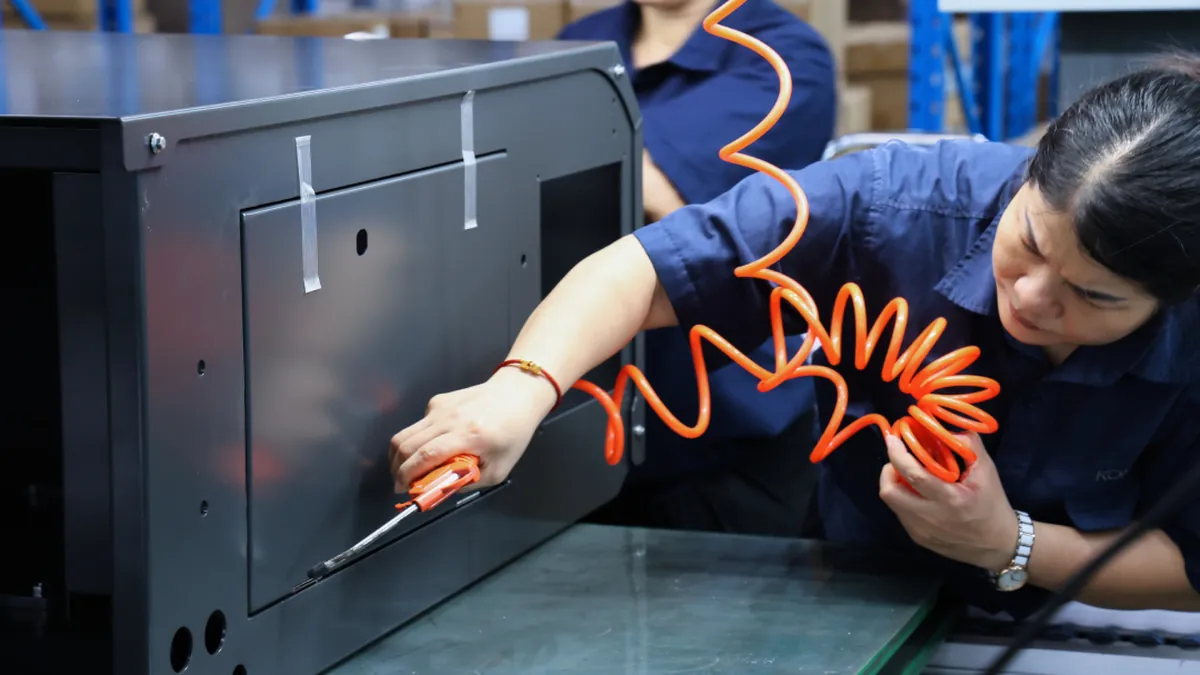 Komaspec on-site industrial assembly worker executing precise box build enclosure manufacturing operations