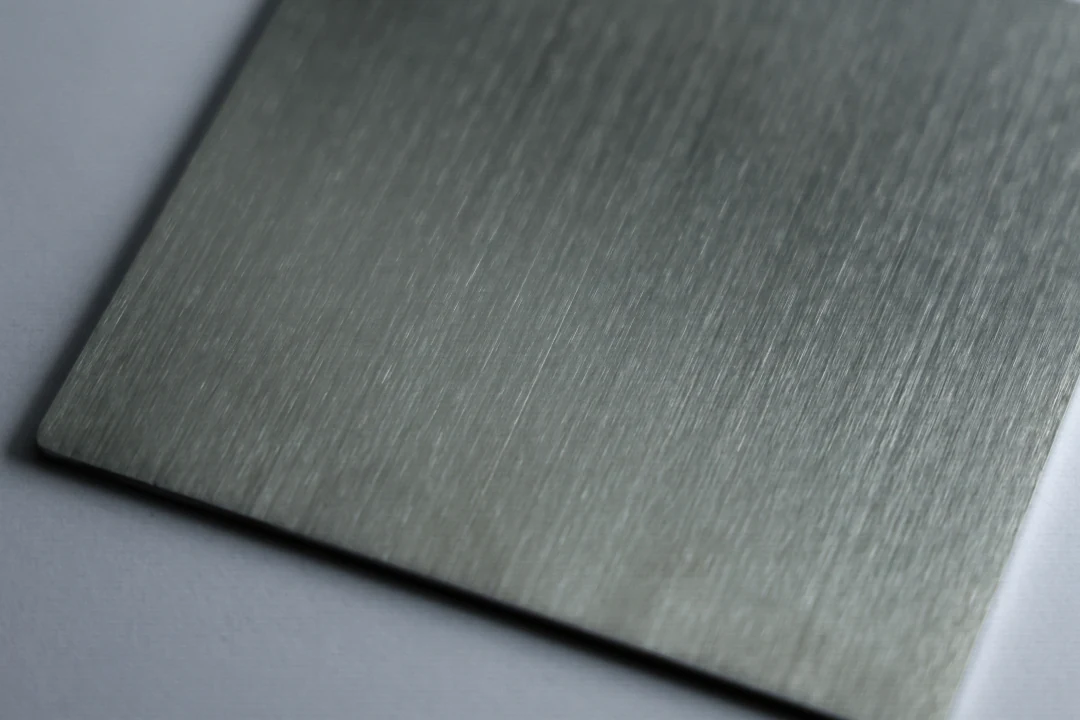 Brushed stainless steel sample at 240 grit showing a fine brushed grain