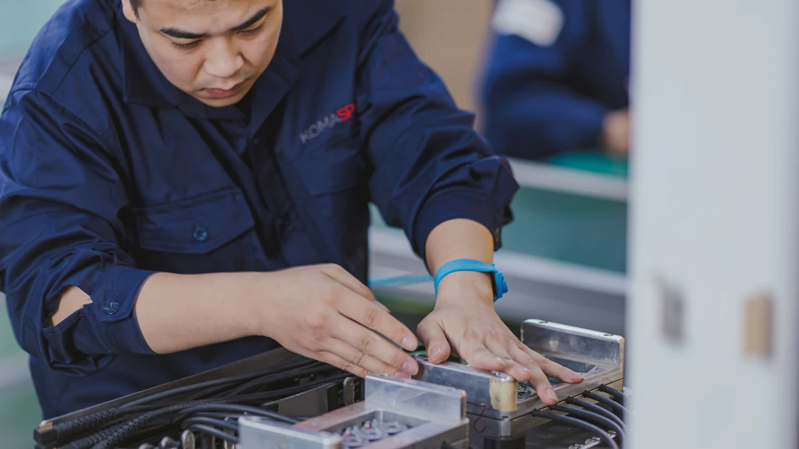 Technician wiring a connector cable into a circuit board assembly