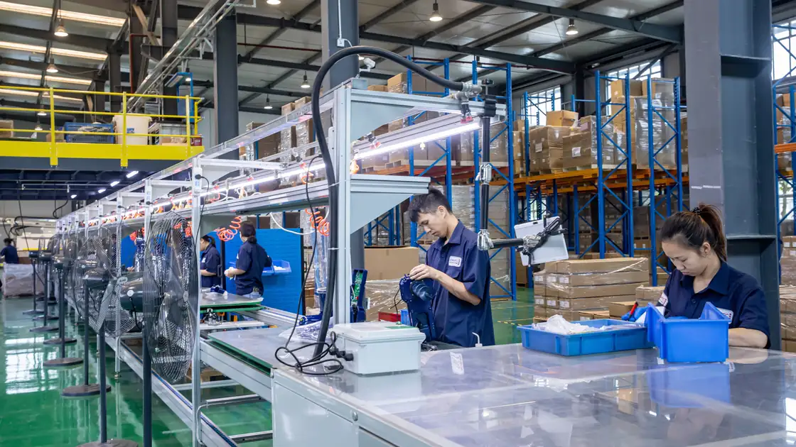 Komaspec production floor with assembly stations and workers along the line