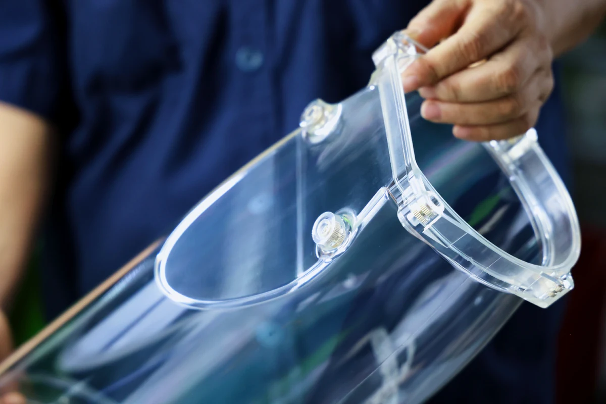 Cross-section of a clear molded plastic part showing knurled inserts embedded in the housing