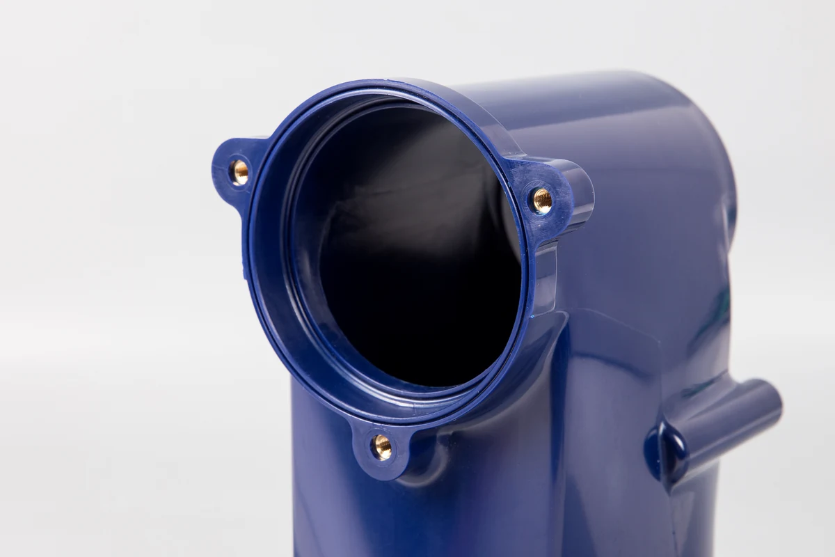 Close-up of a brass threaded insert embedded in a blue injection-molded plastic housing