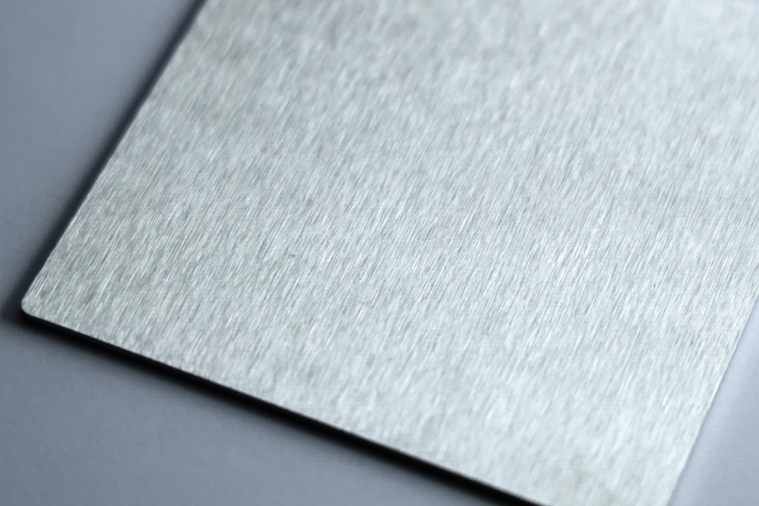 Brushed stainless steel sample at 120 grit showing a clear, even brushed grain