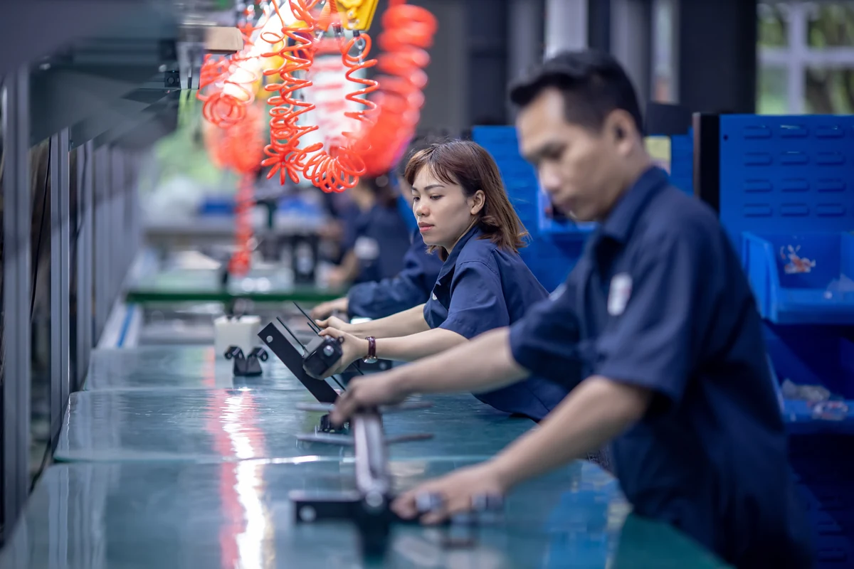 Operator at a contract manufacturing assembly workstation building an electro-mechanical product