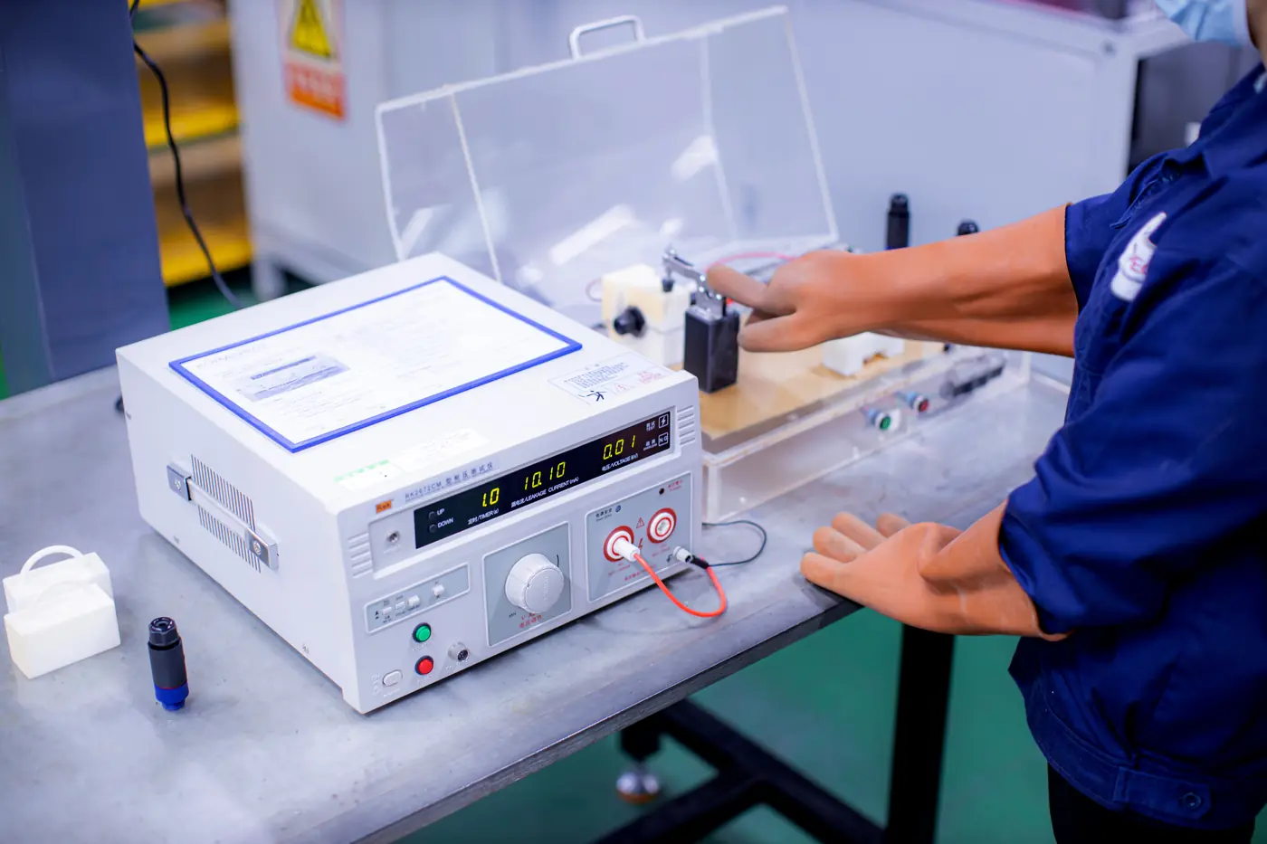 A Komaspec technician conducts electrical safety testing during the DVT phase