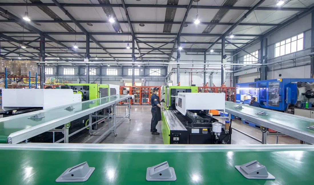 Tecnico che aziona una pressa per stampaggio a iniezione Yizumi nel reparto di produzione