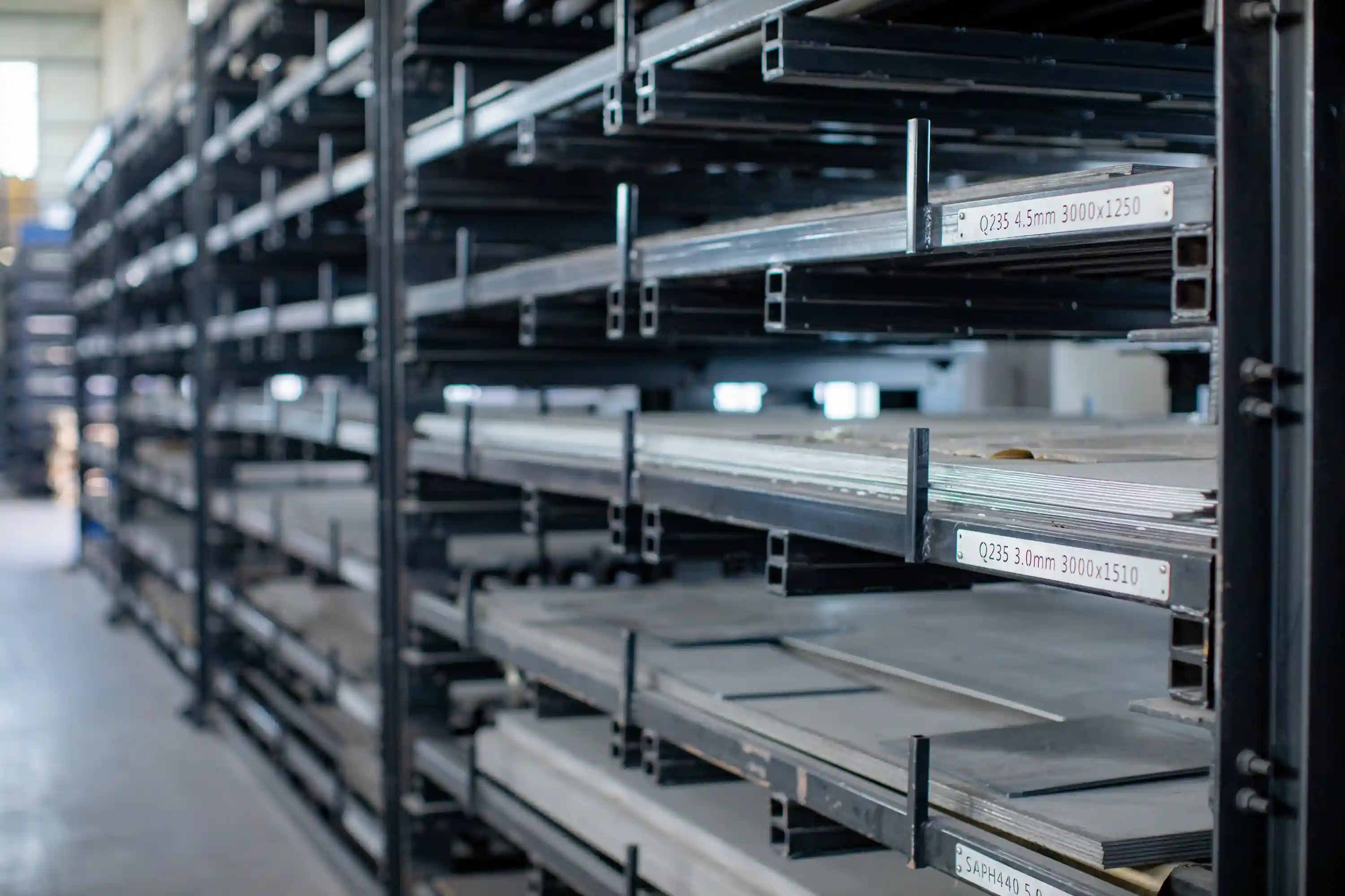 Raw sheet metal stacks stored on industrial shelves ready for fabrication