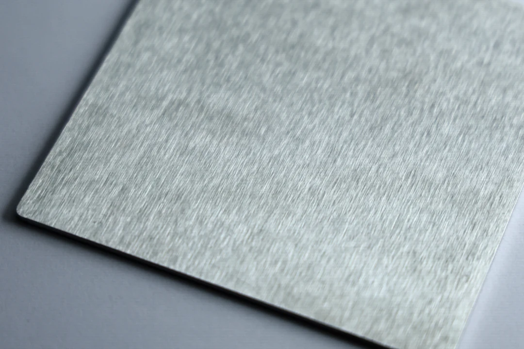Brushed stainless steel sample at 180 grit showing an even brushed grain with finer lines