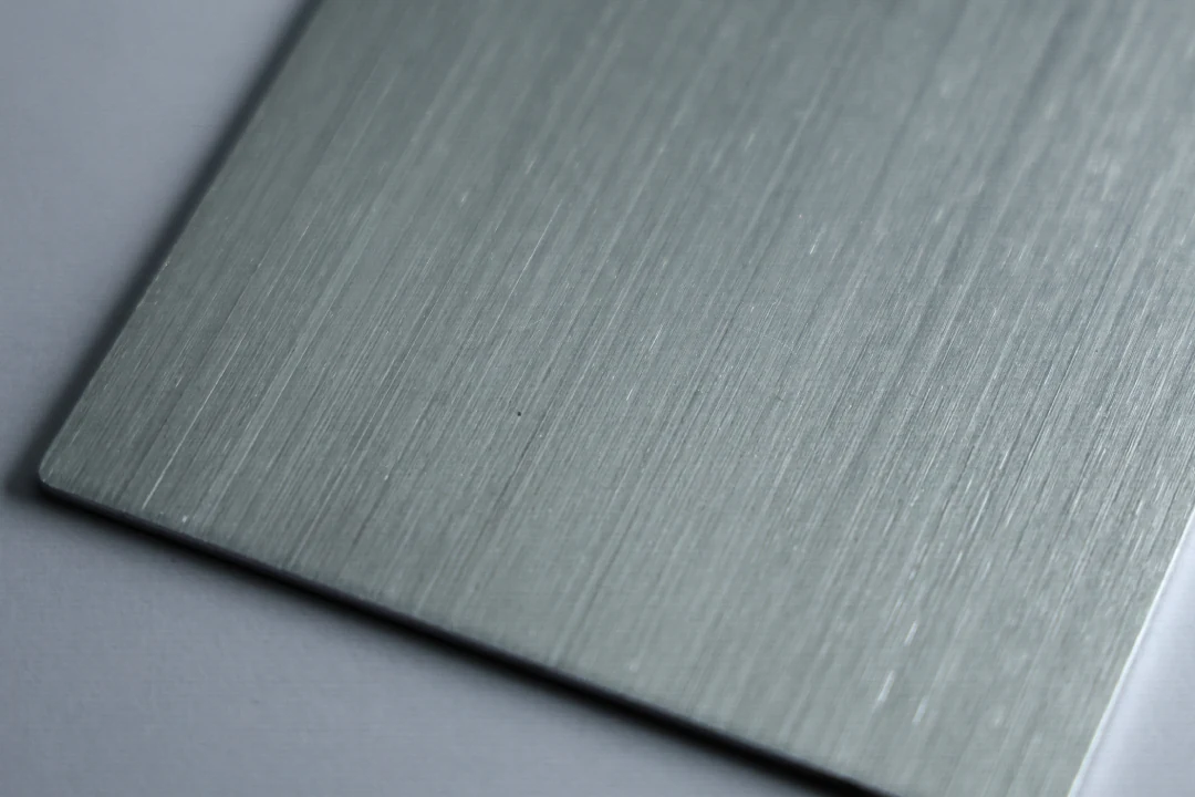 Brushed aluminum sample at 240 grit showing a fine brushed grain