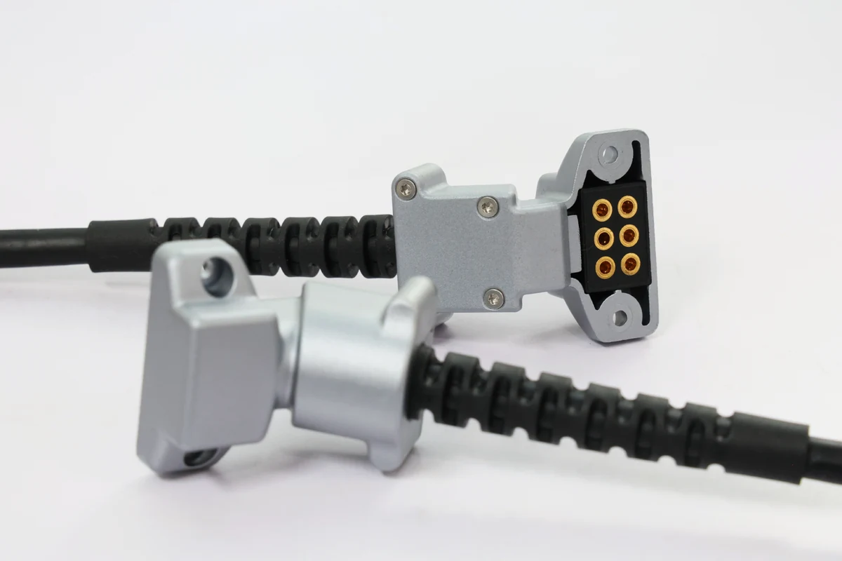 Close-up of overmolded cable connectors with molded strain relief and multi-pin electrical contacts
